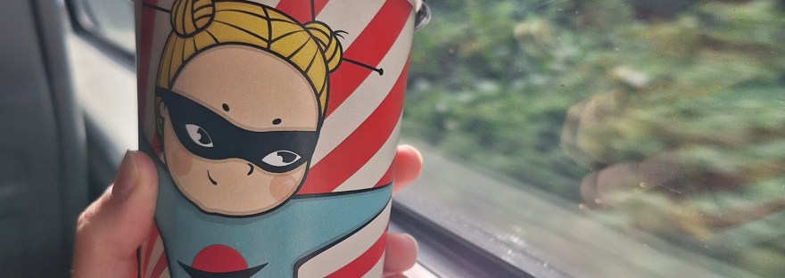 coffee cup held up in front of train window