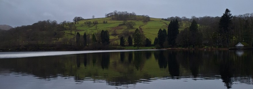 photo taken from a boat on the Lake District of a green hill